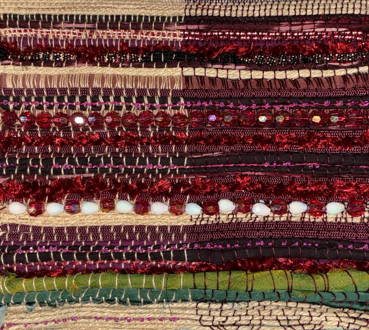 Detail of material swatch showing red beadwork and crushed velvet bands
