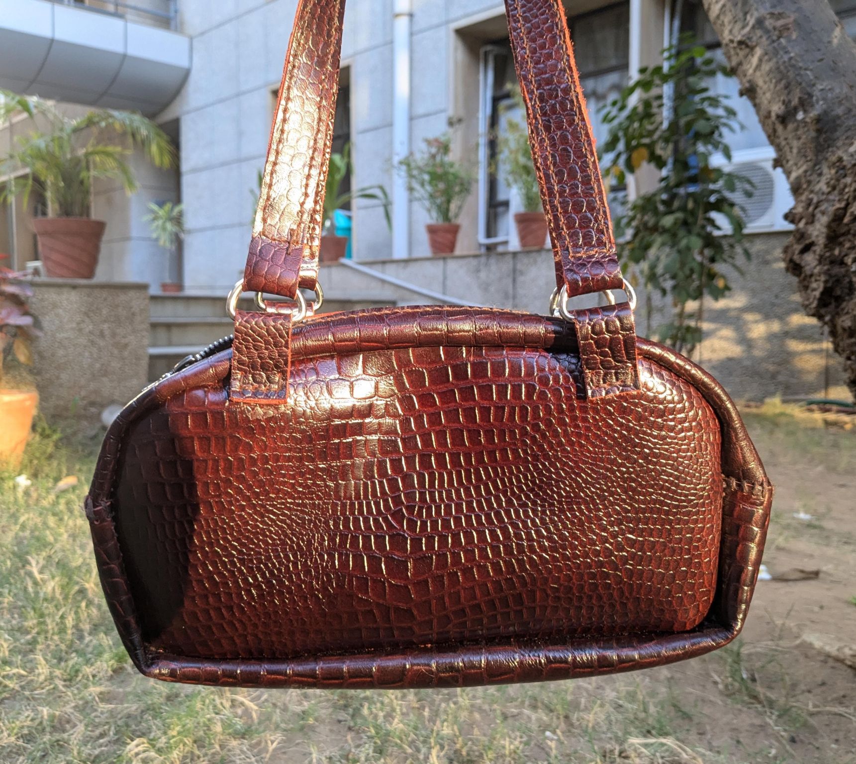 Front view of the leather purse showing the textured finish and strap attachments