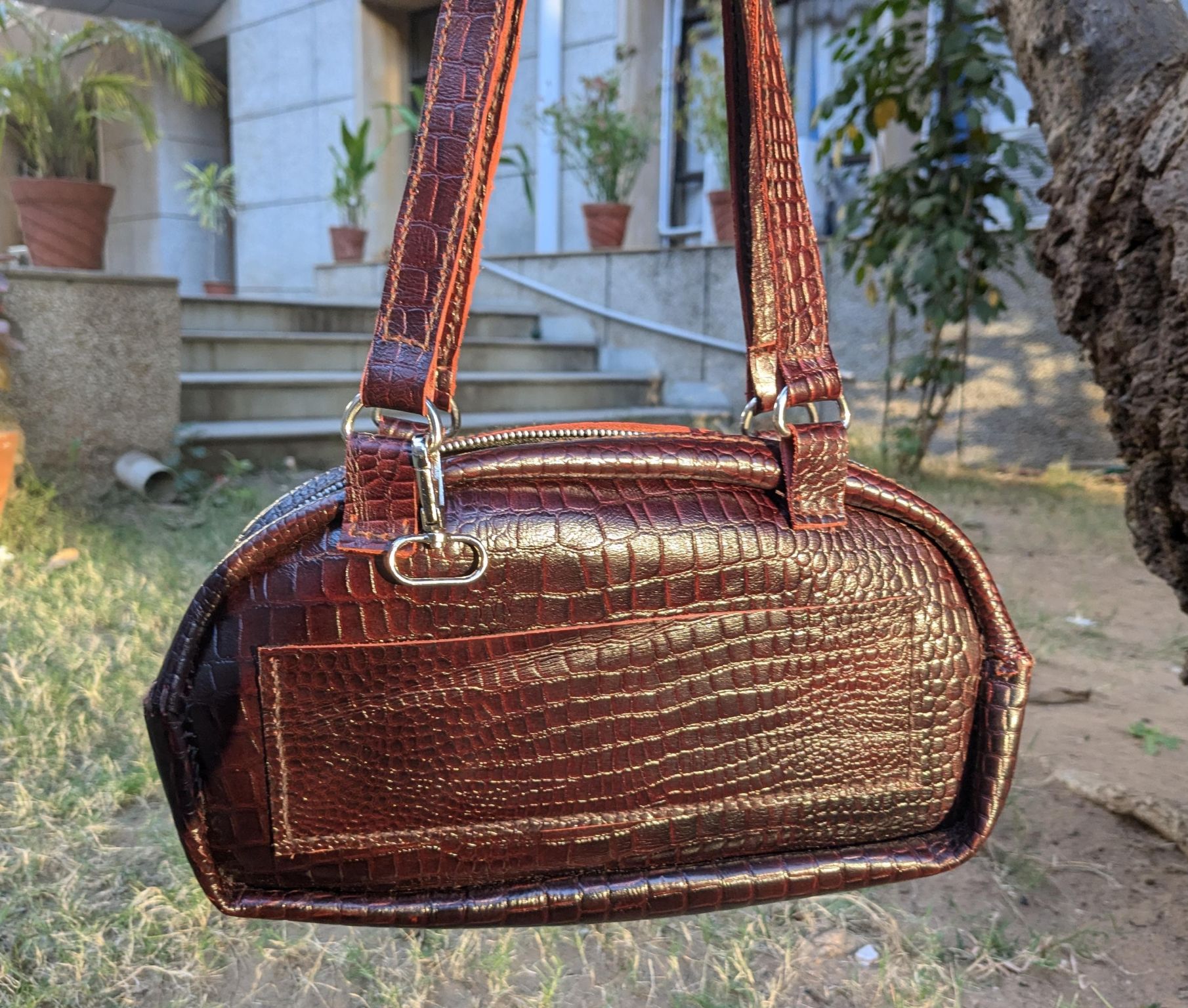 Back view of the leather purse showing the pocket panel and rounded structure