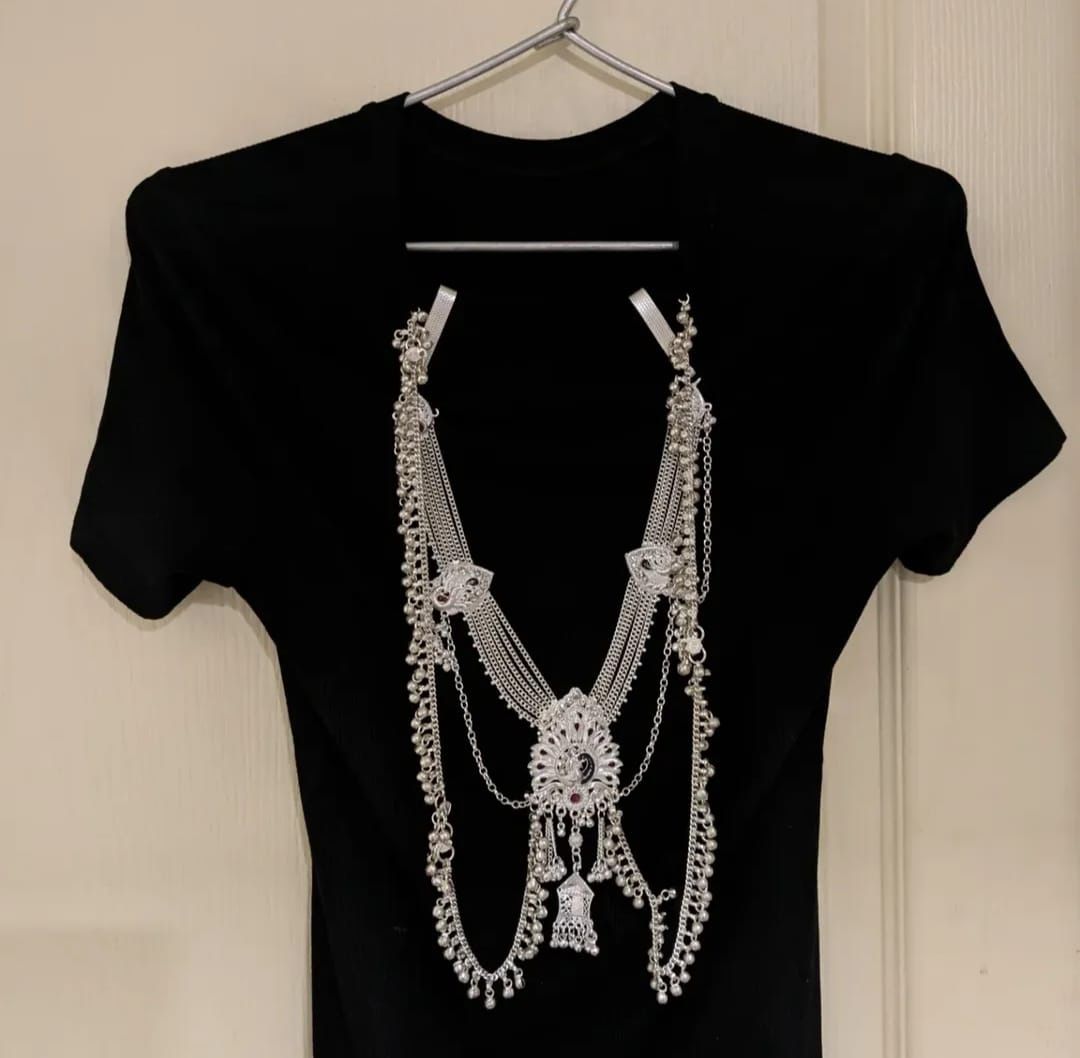 Black garment base with silver chain embellishment arranged as a necklace-like construction
